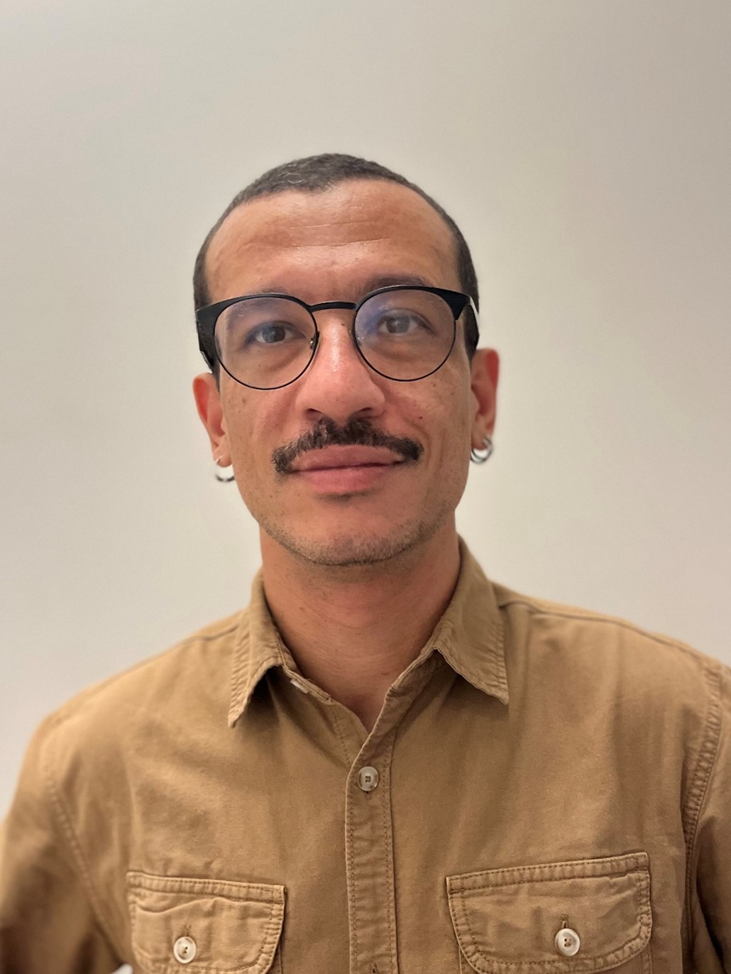 Portrait photograph of Andrew Mecawi smiling.